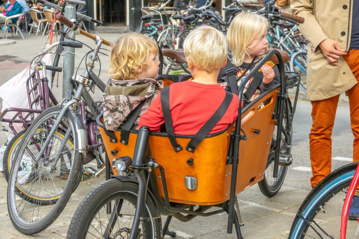 Petits passagers, grandes précautions : trois enfants prêts et sécurisés dans leur vélo cargo
