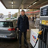 Un automobiliste fait le plein d'une citadine grise à une pompe Gazole d'une station TotalEnergies, par temps gris