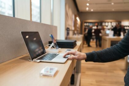 Un client teste un ordinateur portable posé sur un comptoir dans un magasin d'électronique